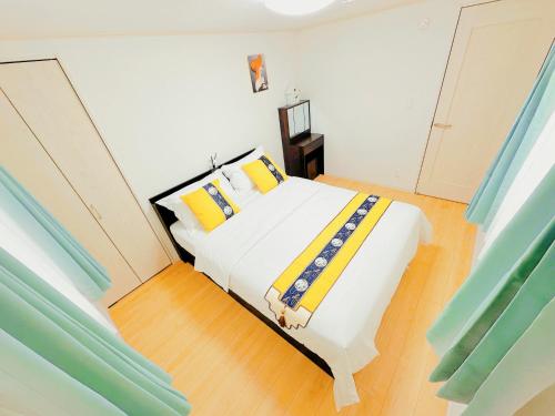 a bedroom with a large white bed with yellow pillows at 吉屋 in Tokyo