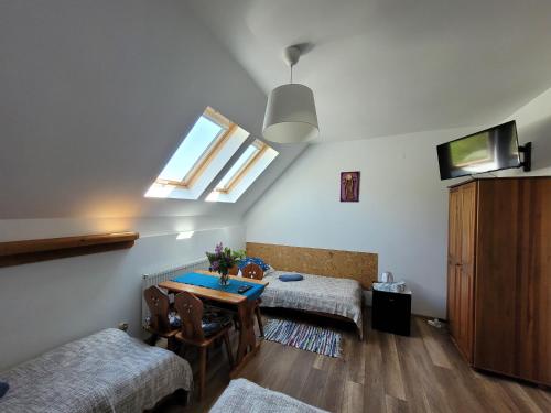 a living room with a table and a window at Oberża Pod Kudłatym Aniołem in Cisna