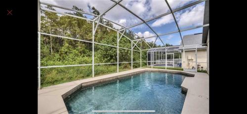 a swimming pool in a house with a glass ceiling at Private house Kissimmee/Orlando in Kissimmee