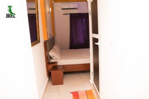 a small bedroom with a small bed in a room at New Green Horse Hotel in Cotonou
