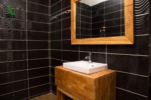 La salle de bains est pourvue d'un lavabo et d'un miroir. dans l'établissement New Green Horse Hotel, à Cotonou