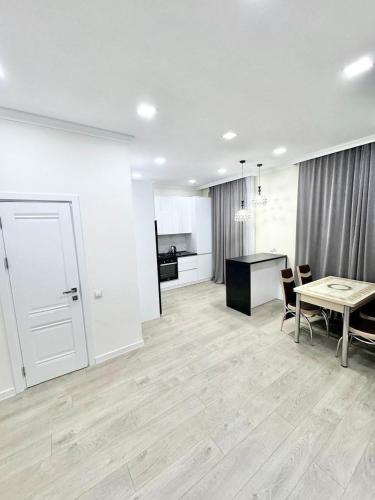 een grote witte kamer met een tafel en een keuken bij Amazing apartament Ultra central in Chişinău