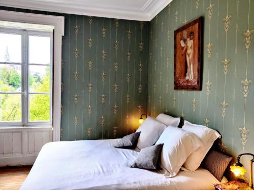 a bed in a bedroom with green wallpaper at VALLÉE 1900 in Torfou