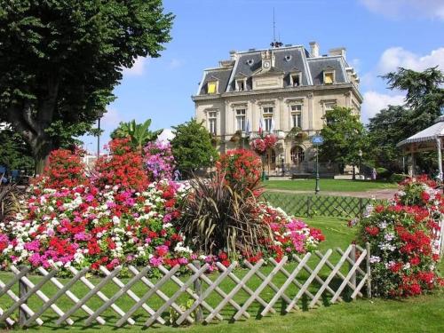 ein weißes Haus mit Blumen davor in der Unterkunft Charming 2-room flat near Paris in Nogent-sur-Marne