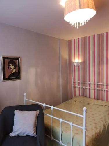 une chambre avec un lit, une lampe et une chaise dans l'établissement Charming 2-room flat near Paris, à Nogent-sur-Marne