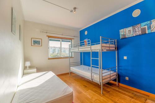 1 dormitorio con litera y pared azul en Stunning View of São Lourenço Beach, en Santo Isidoro