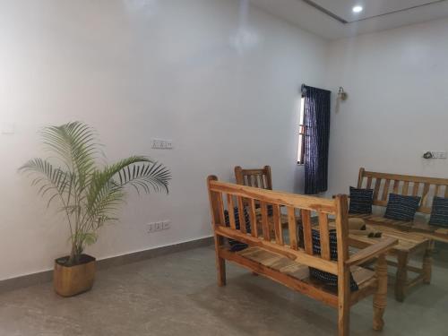 um quarto com bancos de madeira e um vaso de plantas em Le Havre Béninois em Cotonou