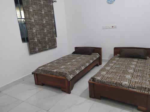 dos camas sentadas una al lado de la otra en una habitación en Le Havre Béninois en Cotonú