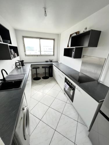 - une cuisine avec des comptoirs noirs et du carrelage blanc dans l'établissement Grenoble ~ Ecole d’architecture ~ Grand-place, à Grenoble