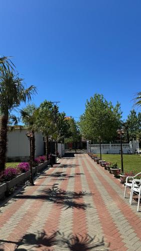 a red brick walkway with trees and flowers at Apartments Costa Azzurra in Velipojë