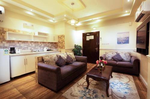 a living room with two couches and a table at Hotel Gardens view in Taif