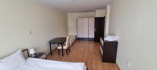 a room with a bed and a desk and a table at Elit Pamporovo Accommodation in Pamporovo