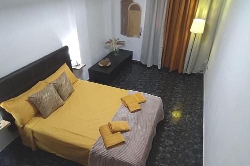 - une chambre avec un lit et 2 serviettes jaunes dans l'établissement CASA MARY, Céntrico y amplio piso cerca del mar, en Candelaria, à Candelaria