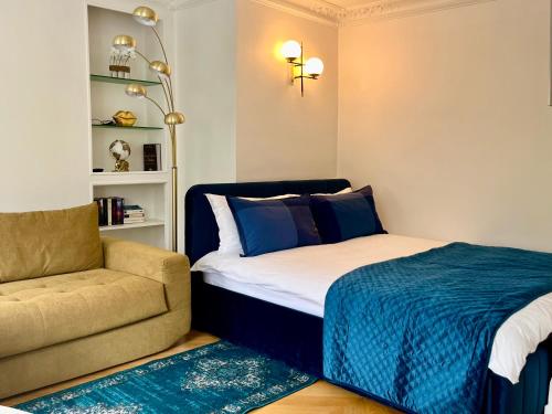 une chambre avec un lit, un canapé et une chaise dans l'établissement Studio près des Champs-Élysées, à Paris