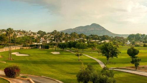 un parcours de golf avec une montagne en arrière-plan dans l'établissement Cosy Villa with Private Pool and Mountain View, à Benitachell