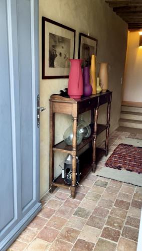 une pièce avec une table avec des vases roses dessus dans l'établissement La Maison de la Lande, à Cuissai