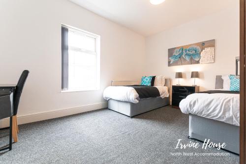 a bedroom with two beds and a window at Irvine Contractor Accommodation in Leigh