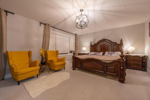 um quarto com uma cama e 2 cadeiras amarelas em Huge House em Ottawa
