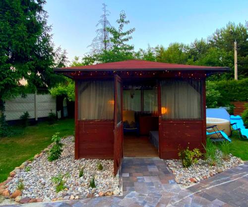 a red gazebo sitting in a yard at Dom Pracy Twórczej Macondo in Miedzno