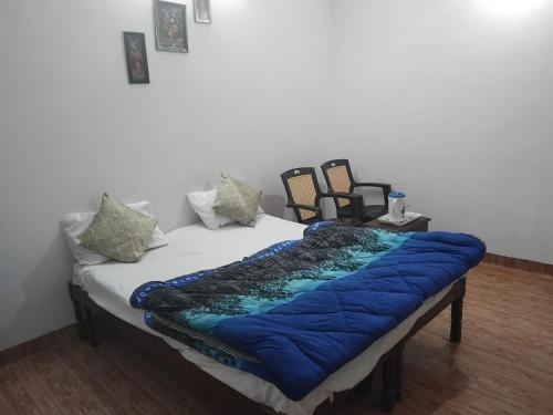 uma cama com um cobertor azul em cima em Shivam Hotel & Restaurant em Khajuraho