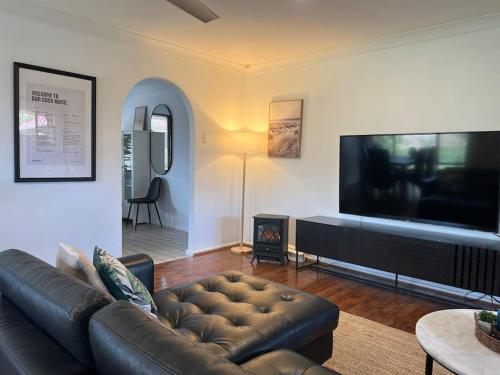 a living room with a couch and a flat screen tv at Humble & Homely in Rockingham