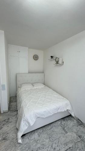une chambre blanche avec un lit blanc dans une pièce dans l'établissement VIP 66 b, à Cannes