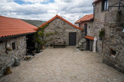 a courtyard of an old stone building with a door at Refúgio Nariz do Mundo (Casa do Meio) in Cabeceiras de Basto