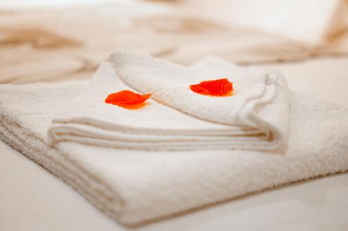 a pile of towels with two red flowers on them at Refúgio Nariz do Mundo (Casa do Meio) in Cabeceiras de Basto