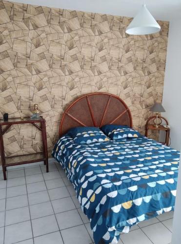 une chambre avec un lit et un mur en pierre dans l'établissement Sartène Appartement 3 pièces vue mer avec jardin, à Sartène