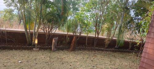a fence with palm trees in front of a building at DESTINY VILLA in Panhāla