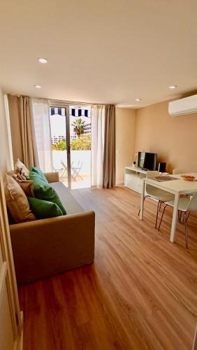 a living room with a couch and a table at Appartamento Las Americas aria condizionata wi-fi in Arona