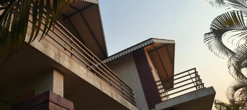 a building with a balcony and a palm tree at DESTINY VILLA in Panhāla