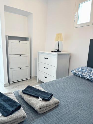 a bedroom with a bed with towels and a dresser at Piso en el corazón de Alicante in Alicante