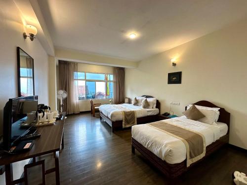 a hotel room with two beds and a television at HOTEL RENDEZVOUS in Gangtok