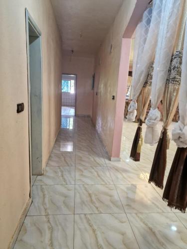 a hallway with white marble flooring and a hallway with curtains at RESIDENCE DU PELERIN - Villa l'écrin de verdure à Bandjoun in Bandjoun
