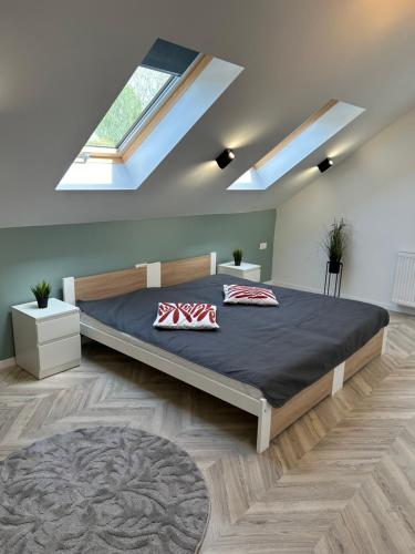 a bedroom with a large bed in a room with skylights at B-Home in Göd