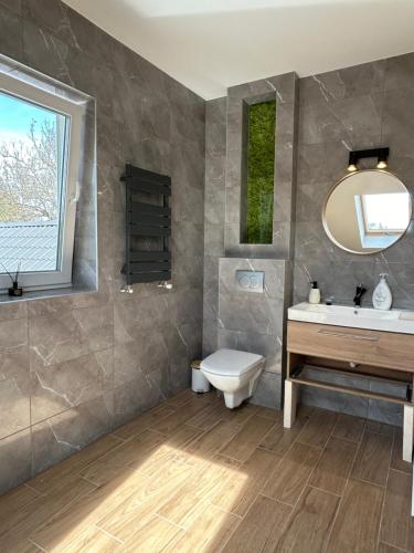 a bathroom with a sink and a toilet and a mirror at B-Home in Göd