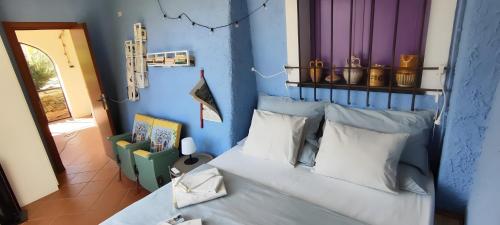 um quarto azul com uma cama com almofadas brancas em SBILENCA & SBILENCHINA - TOP per MTB - Climbers e Famiglie - giardino - BBQ - nel Finalese em Calice Ligure