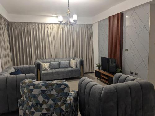a living room with two couches and a tv at Casa Feliz - Stylish 2 Bedroom Apartment in Addis Ababa