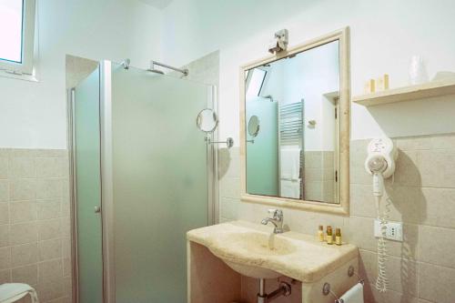 a bathroom with a sink and a shower with a mirror at Casale del Murgese Country Resort in Savelletri di Fasano