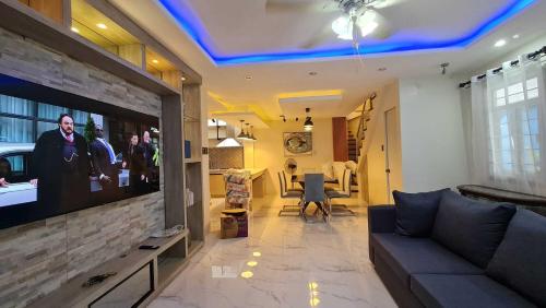 uma sala de estar com um sofá e uma televisão de ecrã plano em Casa Nayah em Cebu
