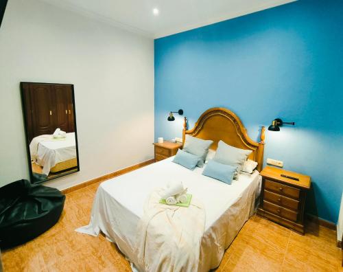 a bedroom with a large bed with a blue wall at El Chivero in Fuengirola