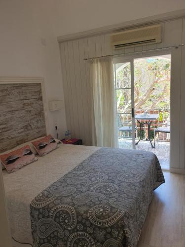 sypialnia z łóżkiem i przesuwnymi szklanymi drzwiami w obiekcie Hostal Mi Campaña w mieście Denia