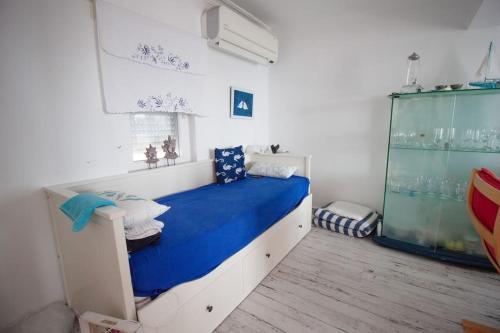 - une chambre avec un lit doté de draps bleus et une fenêtre dans l'établissement 4 Yatak Odalı Şık Villa, à Milas