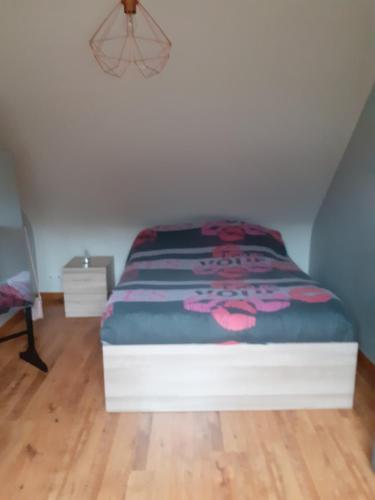 - une chambre avec un lit et une couverture colorée dans l'établissement Maison à la campagne proche de l'Océan, à Le Juch