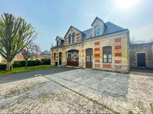 une vieille maison avec une allée en face de celle-ci dans l'établissement Appartement cosy- centre de Douvres la Delivrande, à Douvres-la-Délivrande