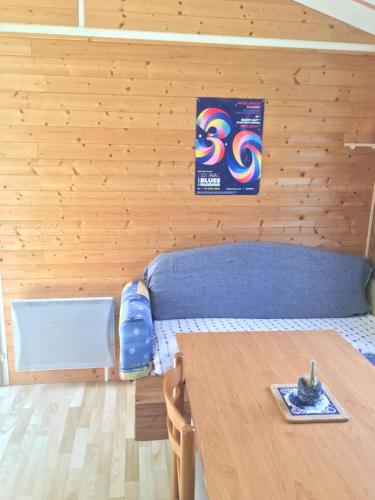 a room with a bed and a wooden wall at Gîte pura vida in Périssac