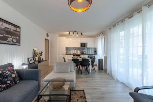 a living room with a couch and a table at Appartement Cosy Rez de jardin in Bénerville-sur-Mer