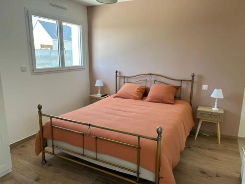ein Schlafzimmer mit einem Bett mit orangefarbener Bettwäsche und einem Fenster in der Unterkunft Gîte des couleurs avec SPA in Chicheboville