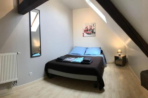 une chambre avec un lit avec des oreillers bleus dans l'établissement La Miltière, maison avec piscine, spa et sauna, à Isigny-le-Buat